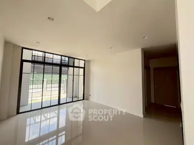 Spacious modern living room with large windows and glossy floors