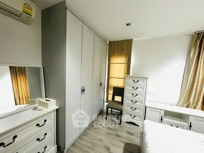 Bright and cozy bedroom with elegant white furniture and natural light.