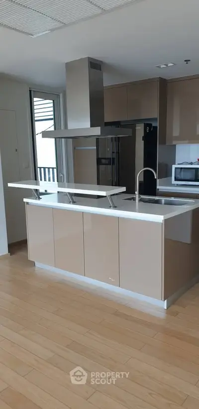 Modern kitchen with sleek cabinetry and island in open layout design.