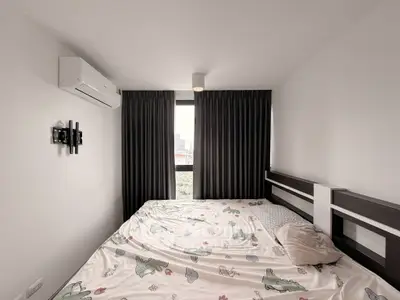 Cozy bedroom with large window and modern air conditioning unit, featuring stylish curtains and playful bedding.