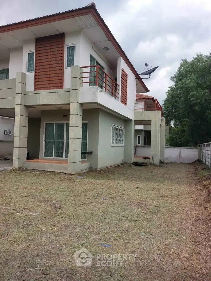 Modern two-story house with spacious yard and contemporary design elements.