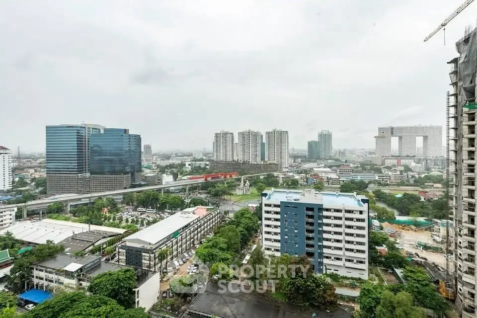 Stunning cityscape view from high-rise building showcasing urban skyline and greenery.