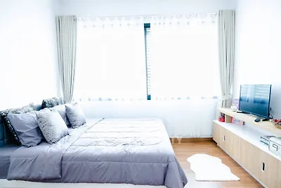 Bright and airy bedroom with modern decor and large windows.