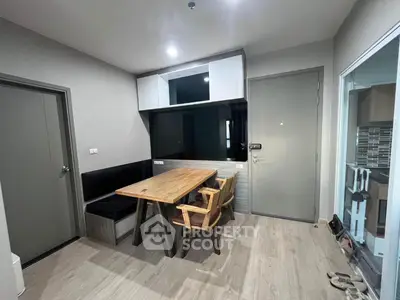 Modern dining area with wooden table and chairs, adjacent to a sleek kitchen space.