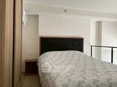 Cozy bedroom with modern decor and stylish bedding in a well-lit apartment.