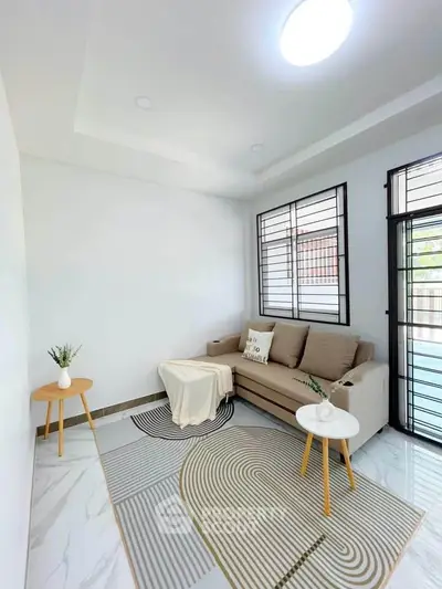 Modern living room with cozy sofa and stylish decor in bright natural light.