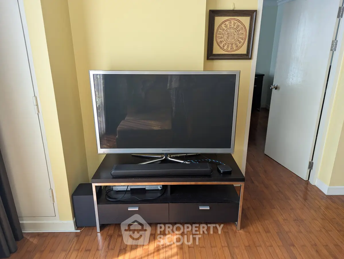 Cozy living room with modern TV setup and wooden flooring