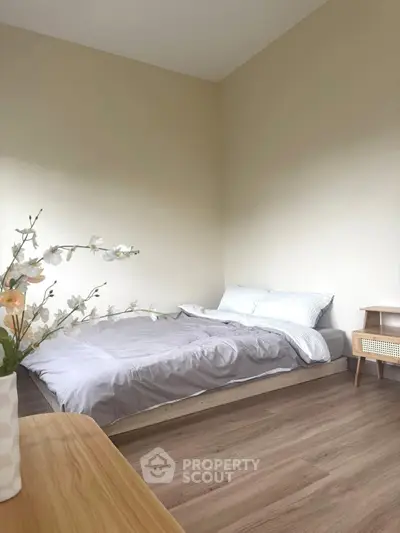 Cozy minimalist bedroom with wooden flooring and soft lighting
