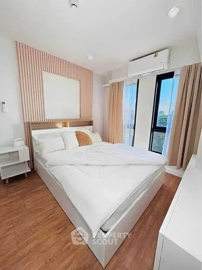 Modern bedroom with stylish decor and large window offering natural light and serene views.