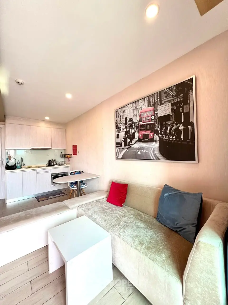 Modern living room with cozy sofa and stylish kitchen in open layout apartment.