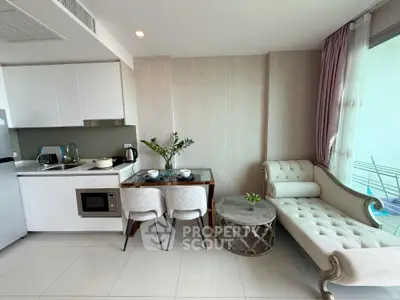 Modern kitchen and dining area with elegant chaise lounge and natural light.