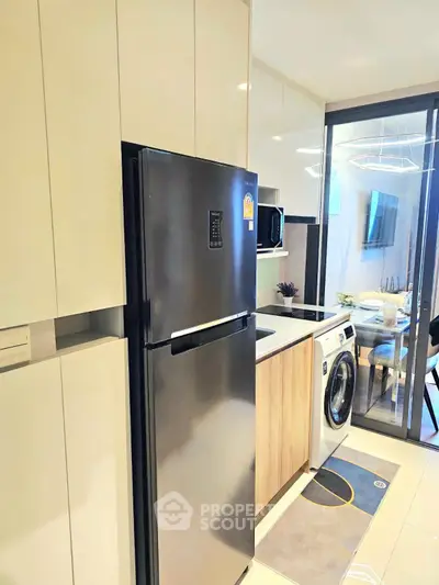 Modern kitchen with sleek appliances and washing machine in a stylish apartment.