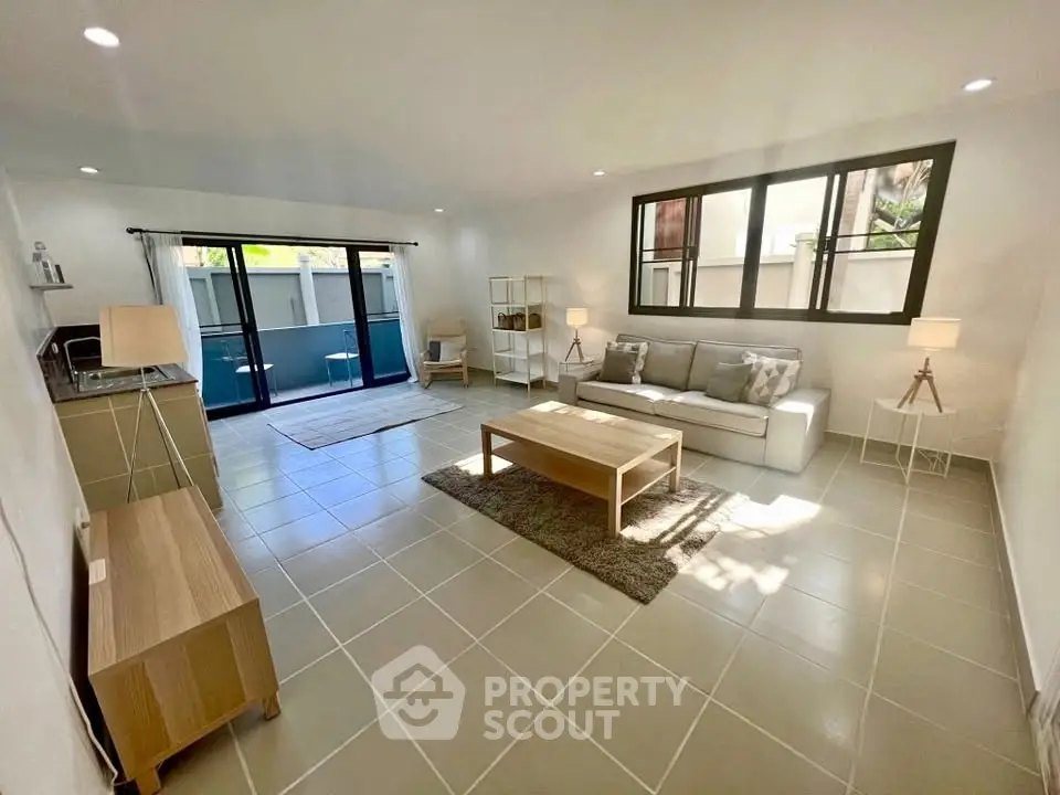 Spacious modern living room with large windows and stylish furniture, perfect for relaxation and entertaining.
