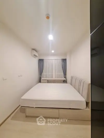 Modern minimalist bedroom with sleek design and ample natural light.