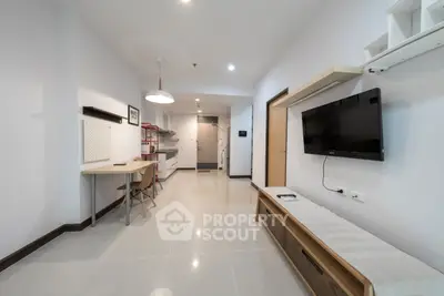 Modern living room with sleek furniture and wall-mounted TV in a contemporary apartment.