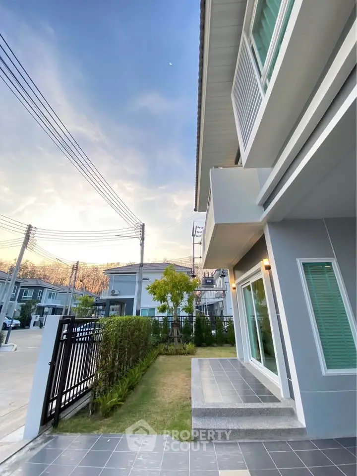 Modern two-story house with sleek design and spacious front yard in a serene neighborhood.