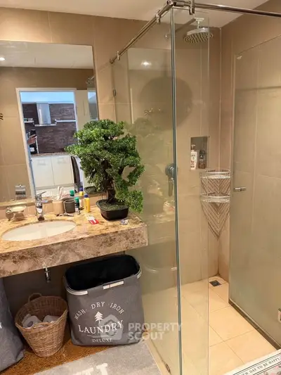 Modern bathroom with glass shower and stylish vanity in upscale home.