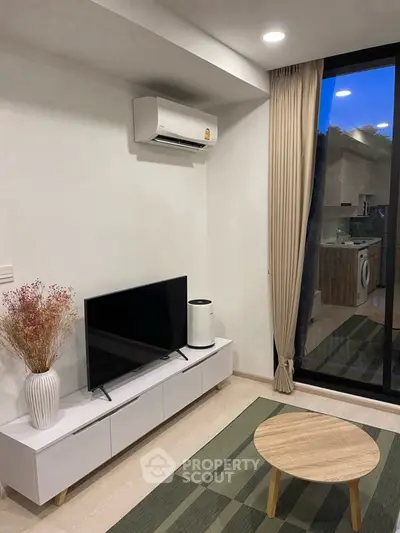 Modern living room with air conditioning, TV, and stylish decor in a cozy apartment setting.