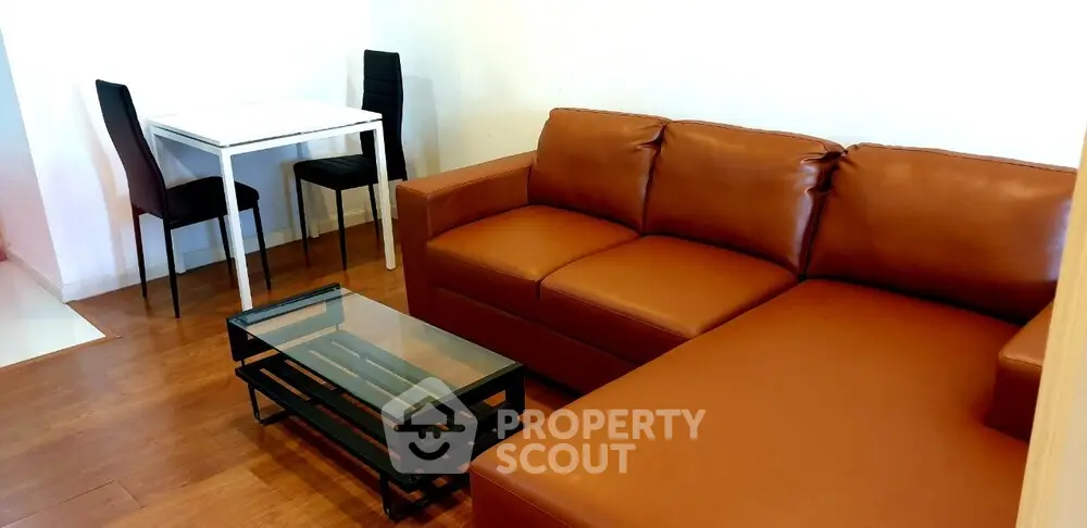 Modern living room with brown leather sofa and glass coffee table