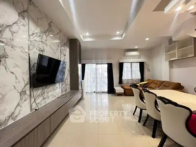 Modern living room with marble accent wall and stylish furniture