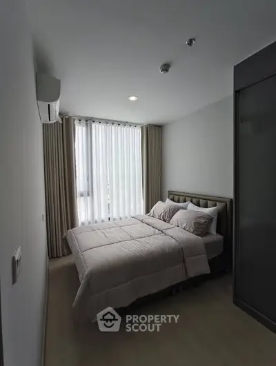 Cozy bedroom with modern decor and natural light from large window