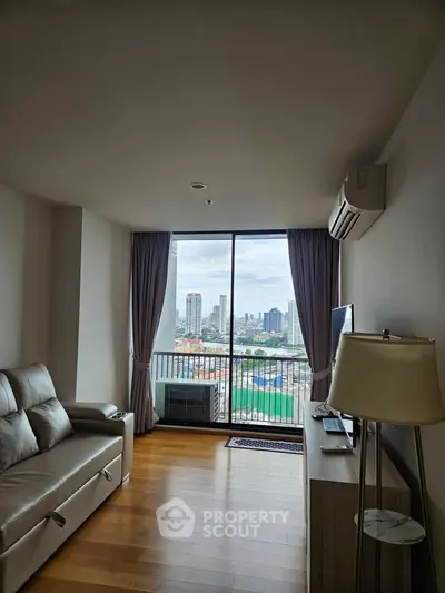 Modern living room with city view, featuring sleek furniture and large windows for natural light.