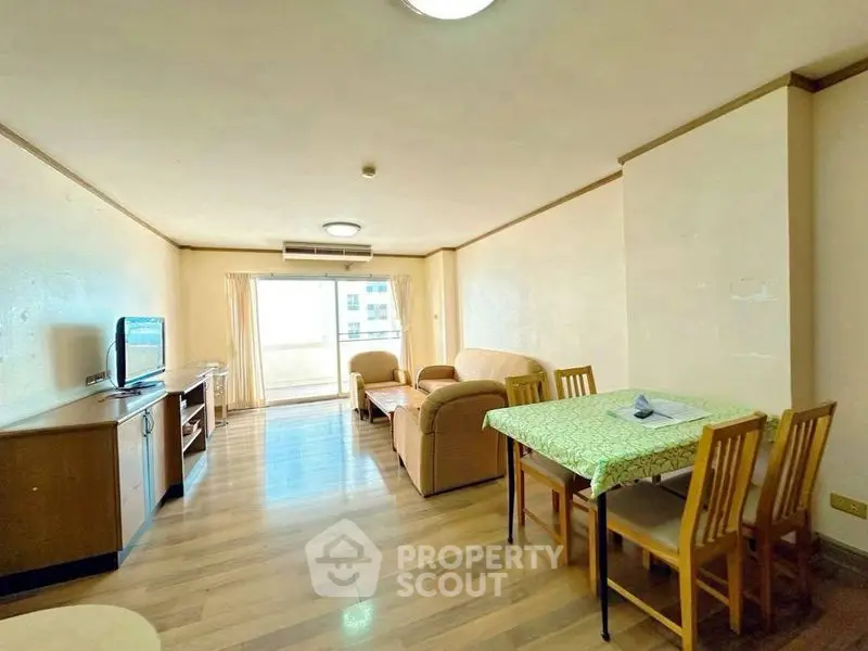 Spacious living room with natural light and modern furnishings in a cozy apartment.