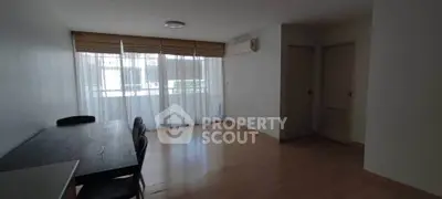 Spacious living room with large windows and wooden flooring, perfect for natural light.