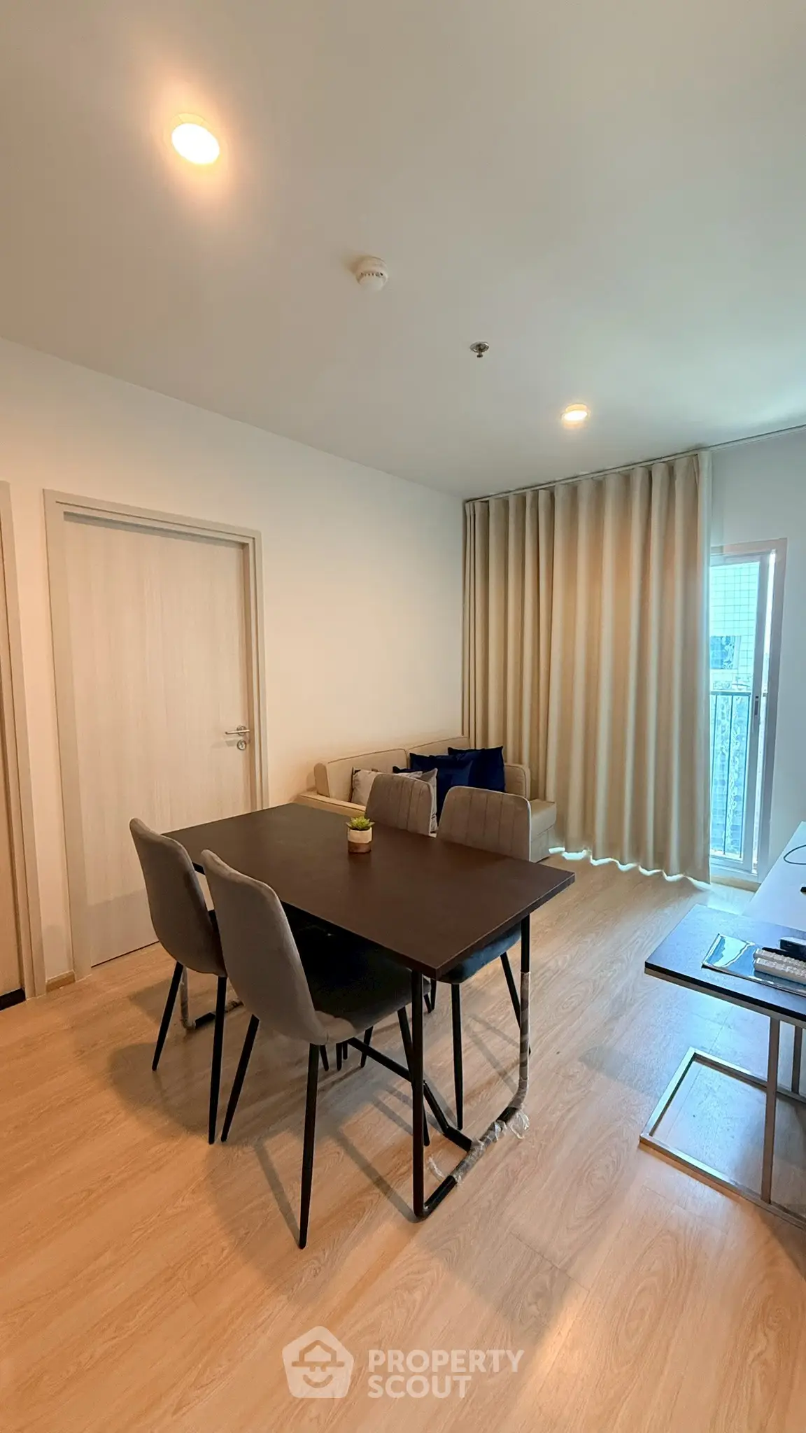 Modern living room with dining area and balcony access in a stylish apartment.