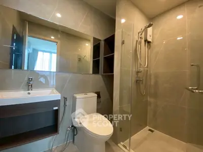 Modern bathroom with glass shower and sleek fixtures in a stylish apartment.