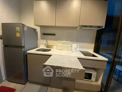 Modern compact kitchen with sleek cabinets and appliances, ideal for urban living.