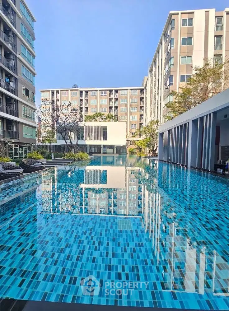 Luxurious apartment complex with stunning pool and modern architecture.