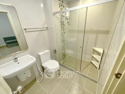 Modern bathroom with glass shower, sleek tiles, and contemporary fixtures.