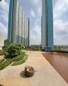 Modern high-rise residential buildings with landscaped garden and open area.