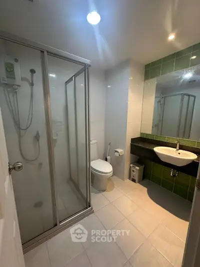 Modern bathroom with glass shower and sleek fixtures in a contemporary apartment.
