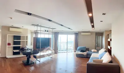 Spacious modern living room with large windows and city view, featuring stylish furniture and wooden flooring.