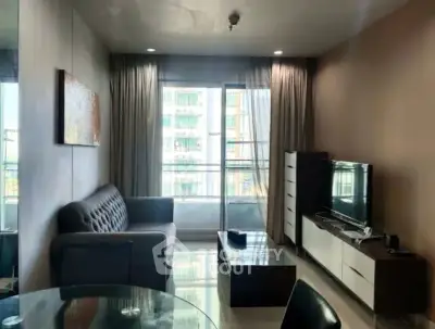 Modern living room with balcony view, stylish furniture, and natural light.