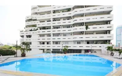 Luxurious apartment building with a stunning outdoor pool and modern architecture.