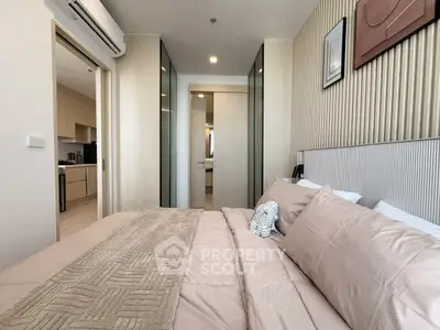 Modern bedroom with elegant decor and view into a stylish kitchen, showcasing open layout design.