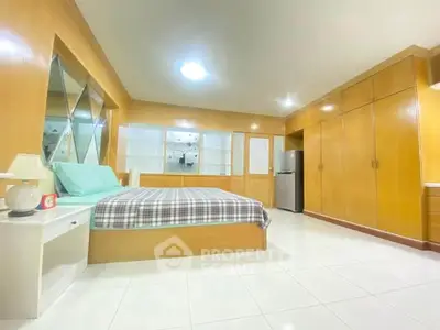 Spacious bedroom with modern design and ample storage in a cozy apartment.