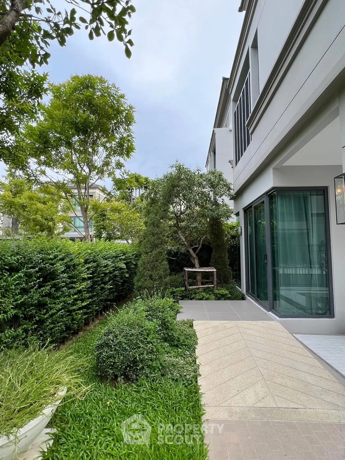 Modern townhouse exterior with lush garden and pathway