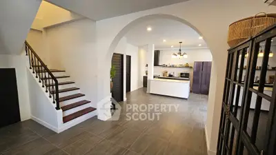 Spacious open-plan kitchen with modern design and elegant staircase, perfect for family gatherings.