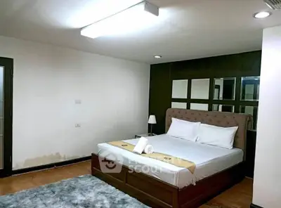 Spacious bedroom with modern decor and cozy lighting, perfect for relaxation.