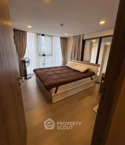 Cozy bedroom with modern decor and large windows for natural light