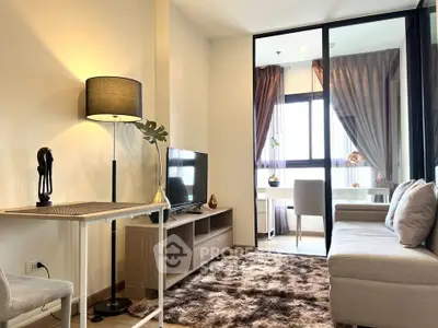 Modern living room with cozy sofa, stylish decor, and natural light from large windows.
