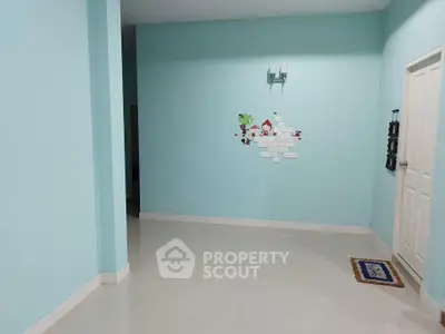 Spacious interior with light blue walls and decorative wall art, ideal for customization.