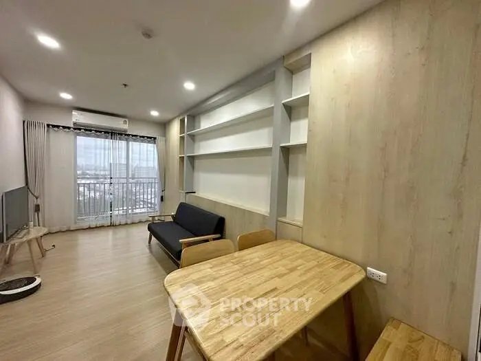 Modern living room with wooden flooring, stylish furniture, and large window offering city view.