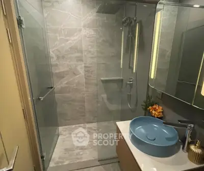 Modern bathroom with sleek shower and stylish blue sink