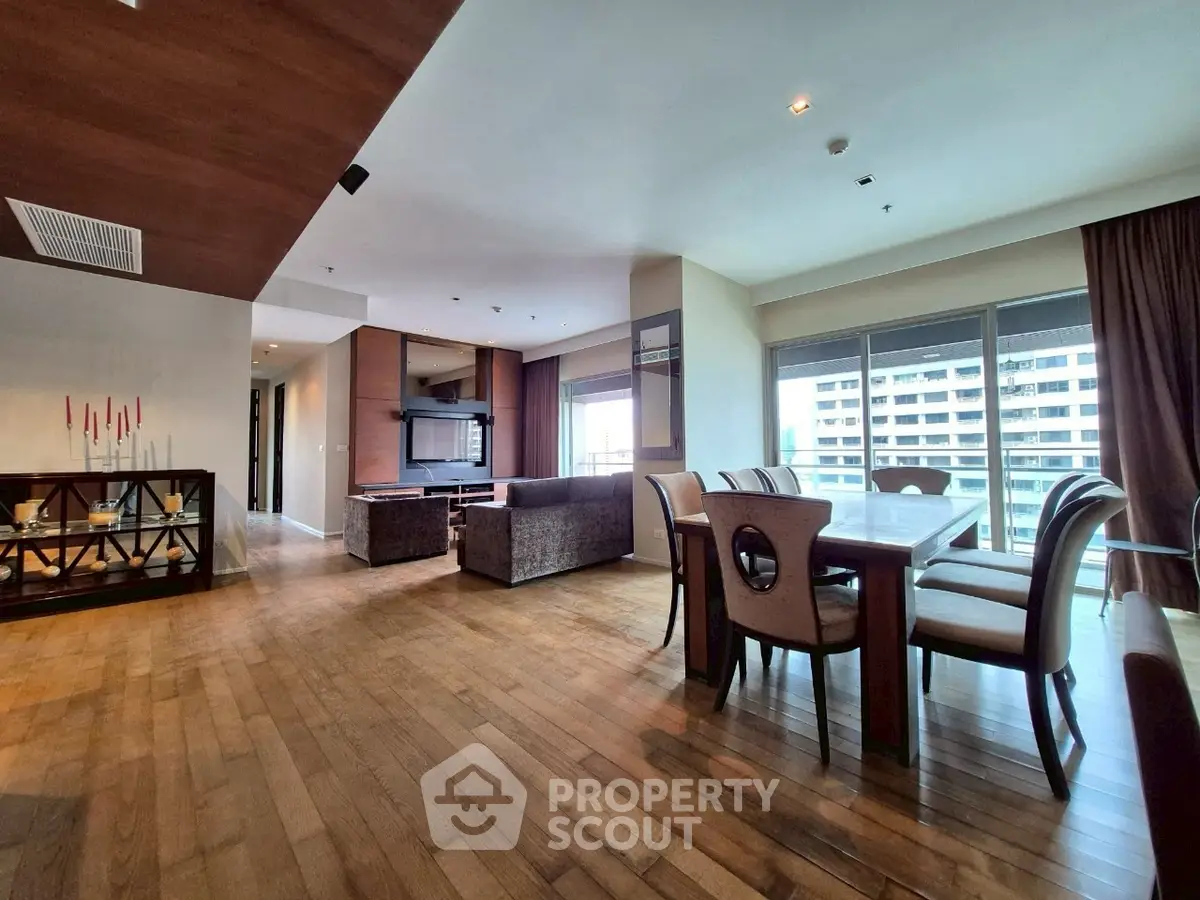 Spacious open-plan living and dining area with modern furnishings and large windows.