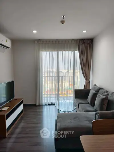 Modern living room with large window and cozy sofa in a stylish apartment.